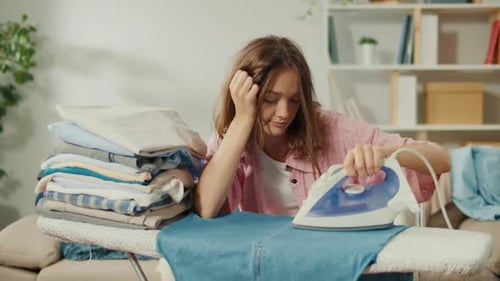 Tired Woman Ironing Clothes at Home