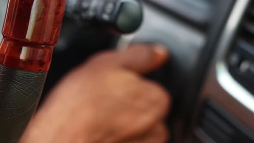 Close up of hand turning the key in the ignition of a car