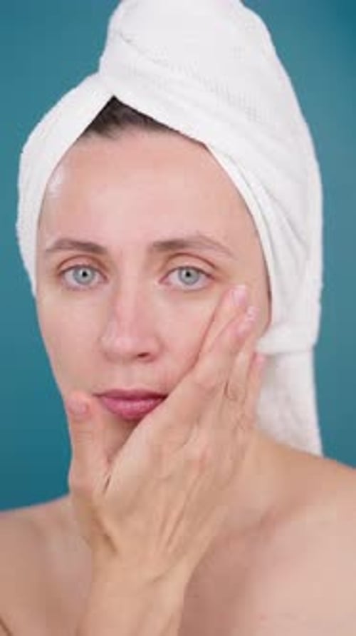 VERTICAL VIDEO Aesthetic Woman Using Hydrating Serum Studio Blue Background