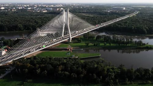 Aerial view of car traffic on modern cable-stayed bridge over river