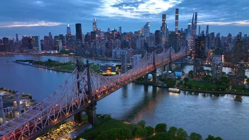New York in lights at evening time. Beautiful Queensboro Bridge with green park