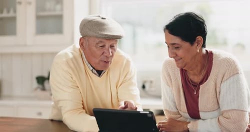 Senior Couple Using Tablet Device at Home