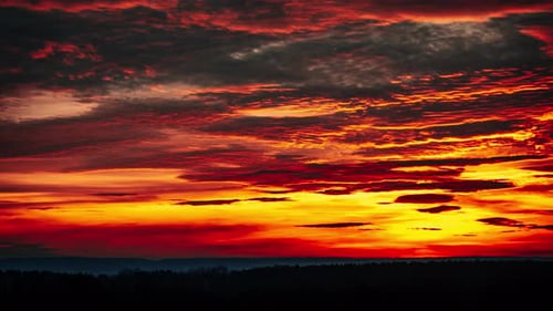 Timelapse of Dramatic Sunset Through Clouds in the Orange Sky Over the Horizon