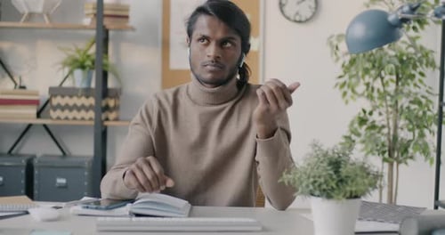 Portrait of Cheerful Indian Businessman Making Online Video Call Speaking and Gesturing From Office