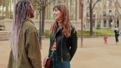 Side view of two young girls talking, dialog of two girlfriends