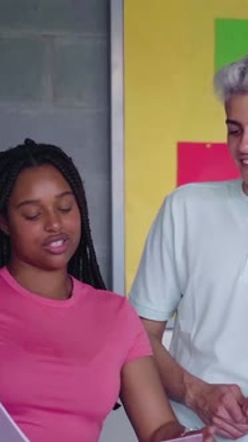 Multiracial Group of University Students Gathered in Classroom Talking About a School Project