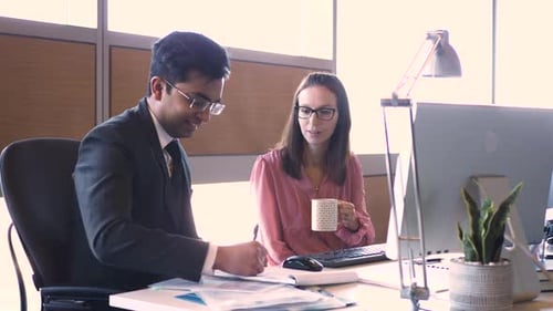 Business professionals discussing ideas at a modern office desk environment