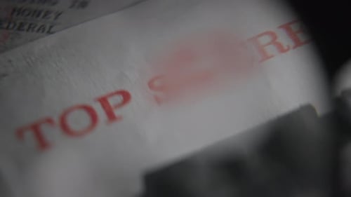 Lupe zeigt auf den roten Stempel der streng geheimen Sicherheitsfreigabe für geheime Informationen