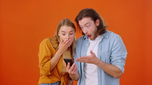 Young Adults Celebrating Success While Looking at Phone