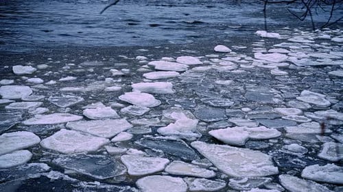 Ice floes scatter across lake surface under wind driven currents