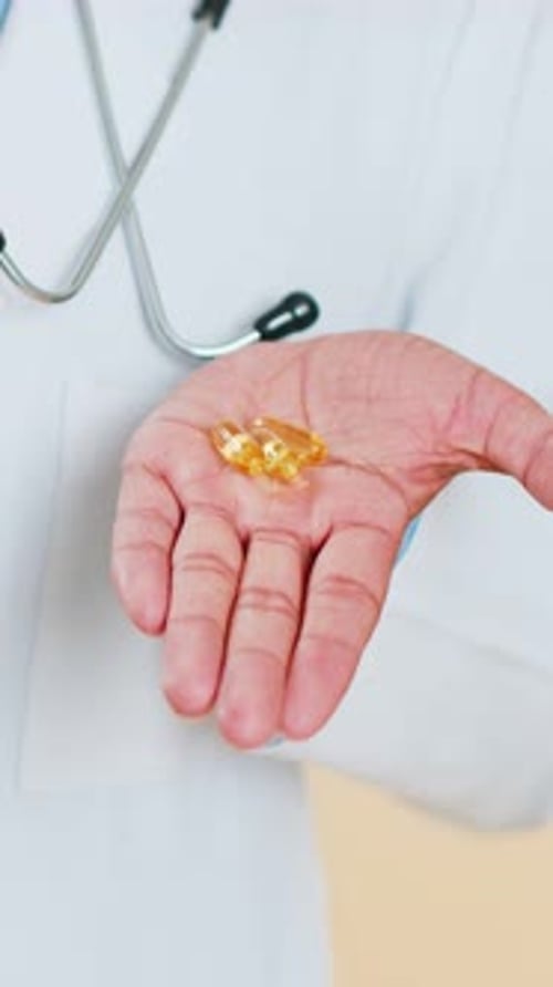 Doctor Man muestra tabletas de omega-3 en la palma de la mano y recomienda medicamentos, tratamiento de inmunización con vitaminas