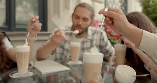 Group of Friends Talk Over Coffee at Outdoor Cafe