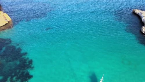 Turquoise Ocean Meets Rocky Coastline on Sunny Day