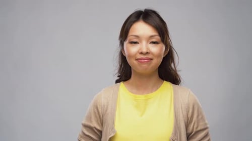 Smiling Young Woman in Yellow Shirt on Gray Background