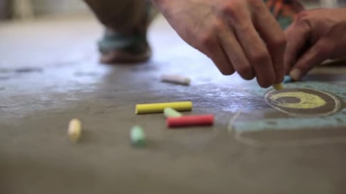 Glass blowers sketching ideas on calgary pavement with chalk in alberta Canada