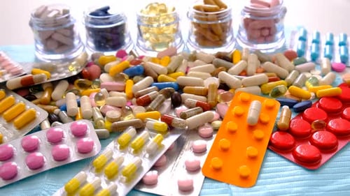 Assorted Pills and Tablets on Blue Surface