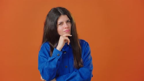 Brunette Woman Presses Finger to Face with Dreamy Expression