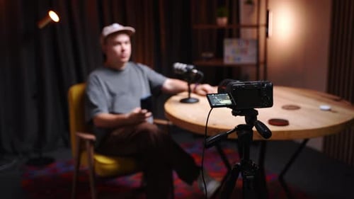 Man Recording Video with Camera and Microphone at Home