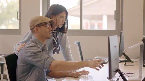 Designer sprechen, während sie den Computer in einem Coworking benutzen