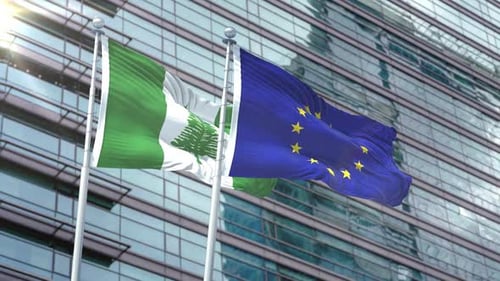 Norfolk Island and European Union Flags Waving Against Modern Building
