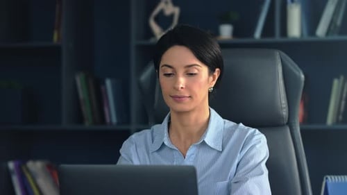 Professional woman focused on laptop in modern office setting