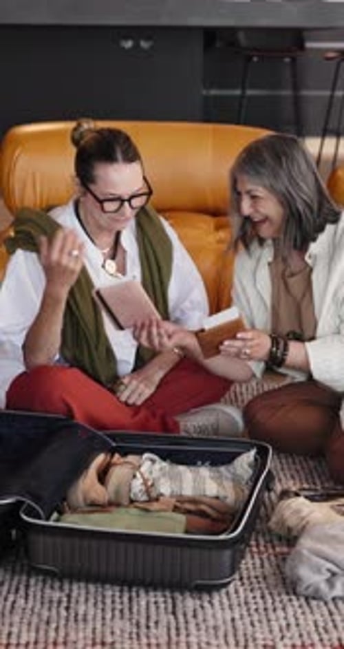 Two Women Packing Suitcase for Travel at Home