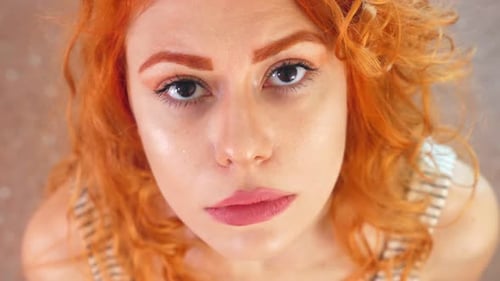 Woman Looking Upward with Curly Red Hair