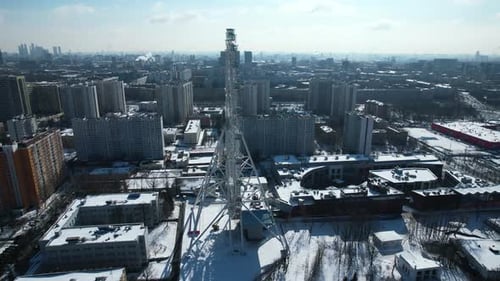 Ferris wheel in center of big city on sunny winter day.