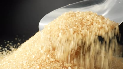 Pouring Brown Sugar onto a Pile with Spoon