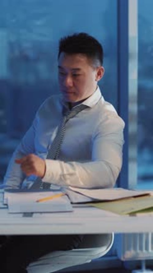 A Focused Professional Diligently Working Late Into the Night in a Modern Office Environment