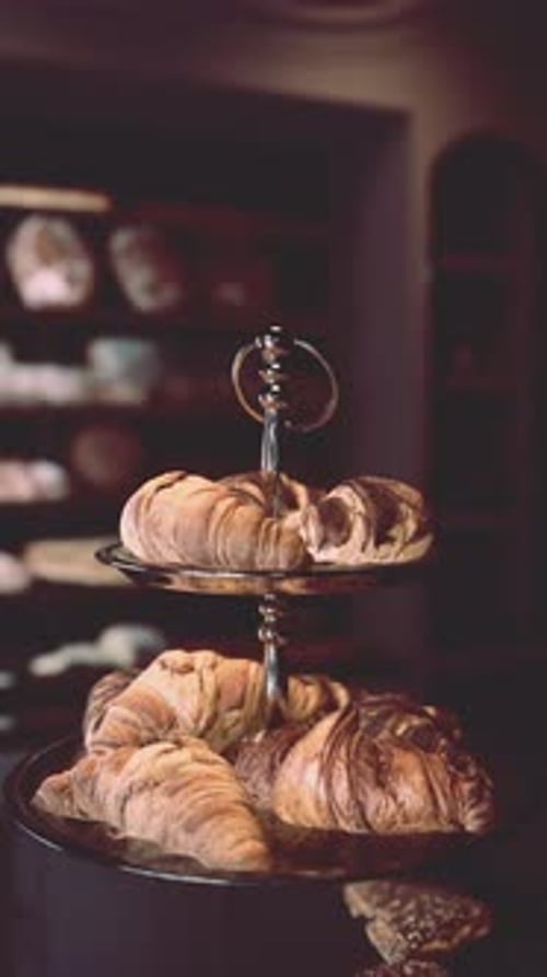 Delicious Croissants Rotating on Tiered Stand Vertical Video