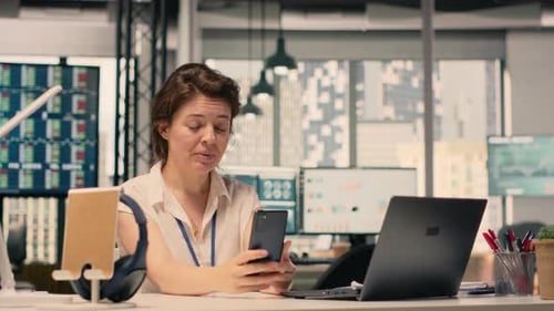 Smiling Woman Participating in Video Call From Workstation in Office