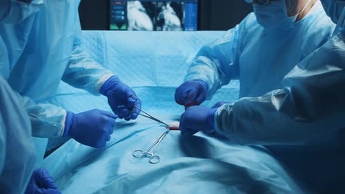 Multiracial Team of Professional Medical Surgeons Performs the Surgical Operation in a Modern