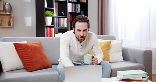 Man Working on Laptop in Cozy Home Setting