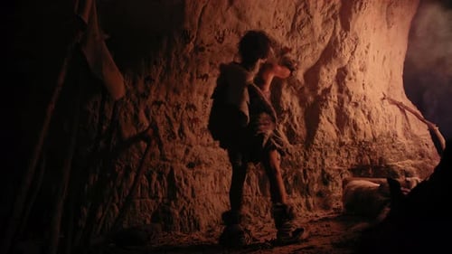 Primitive Man Drawing on Cave Wall at Night