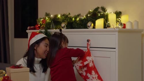 Child Opening Christmas Presents with Smiling Adult