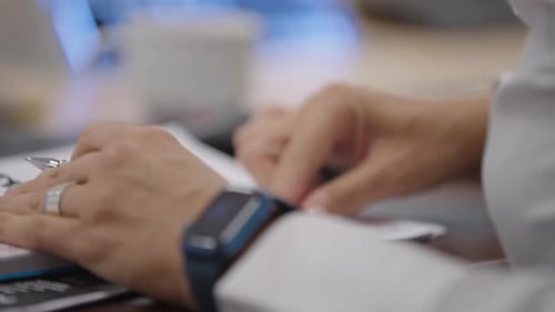 Person Writing in Notebook at Desk