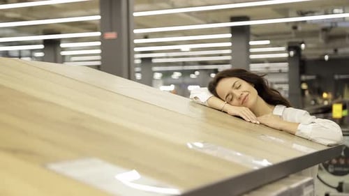 A Woman Chooses Wooden Laminate Floors in a Store Reconstruction and Repair Concept