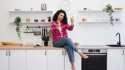 Woman Video Calling on Smartphone in Modern Kitchen