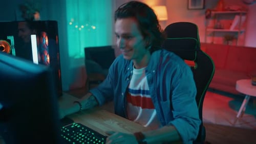 Enthusiastic Young Man Plays Video Games at Home