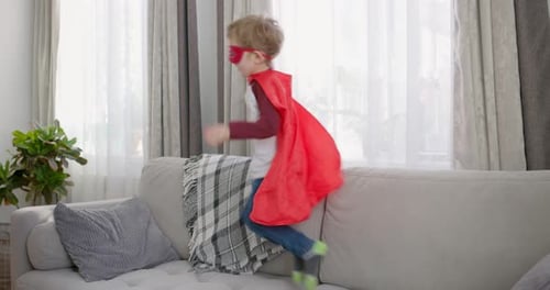 Boy in Superhero Costume Playing on Couch