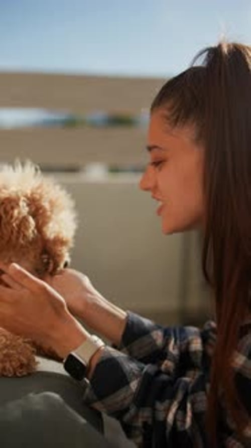 Woman Cuddling Small Dog Outdoors