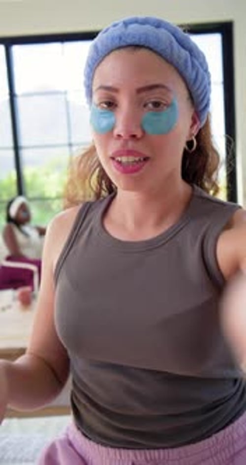 Vídeo vertical: Al iniciar la grabación del teléfono, la mujer muestra parches de gel para hacer una demostración de la rutina por ventana
