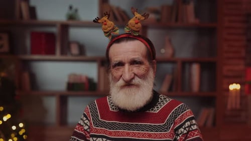 Bearded Senior in Christmas Sweater and Reindeer Headband
