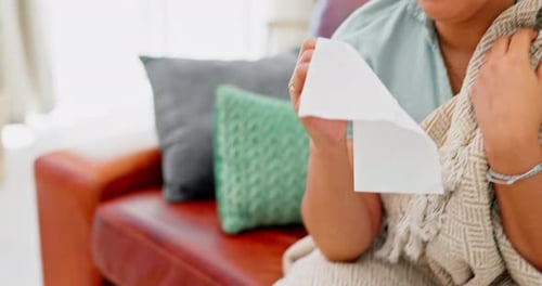 Woman Blowing Nose with Tissue at Home