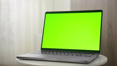 Side View of Laptop with Green Screen on Table Dolly Zoom