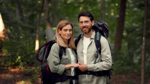 Couple Enjoying Nature While Hiking in the Forest During a Sunny Day