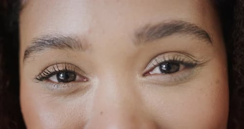 Portrait close up of eyes of happy biracial woman smiling, in slow motion