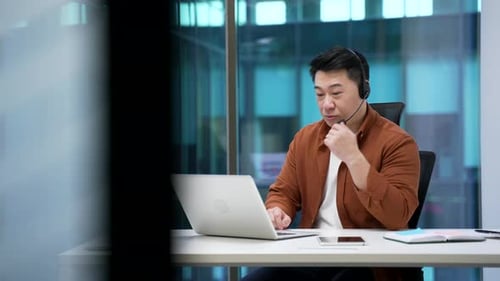 Man Video Conferencing on Laptop in Urban Office