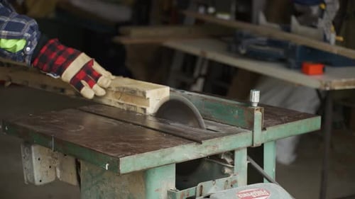 A piece of wood is cut using a circular table saw.